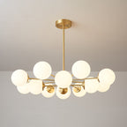 Low, wide Clérachic chandelier with glowing white orbs fanned around a brass centre on a pale grey wall.