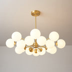 A Clérachic chandelier with a full cluster of lit orbs, the brass drop rod and canopy above, on a warm taupe wall.