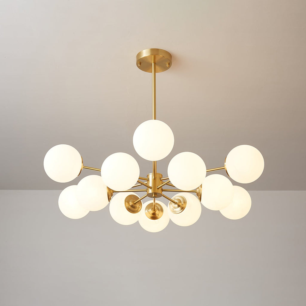 Clérachic chandelier lit with one orb on top and others fanned out below, on a soft beige-grey backdrop.
