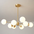 Clérachic chandelier with eight lit orbs spaced wide on long brass arms, on a soft grey backdrop.