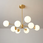 Brass chandelier with glowing orbs on arms of varied length, a Clérachic light with a long drop rod.