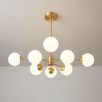 Clérachic chandelier with lit orbs fanned around a brass centre, one orb raised above the others.