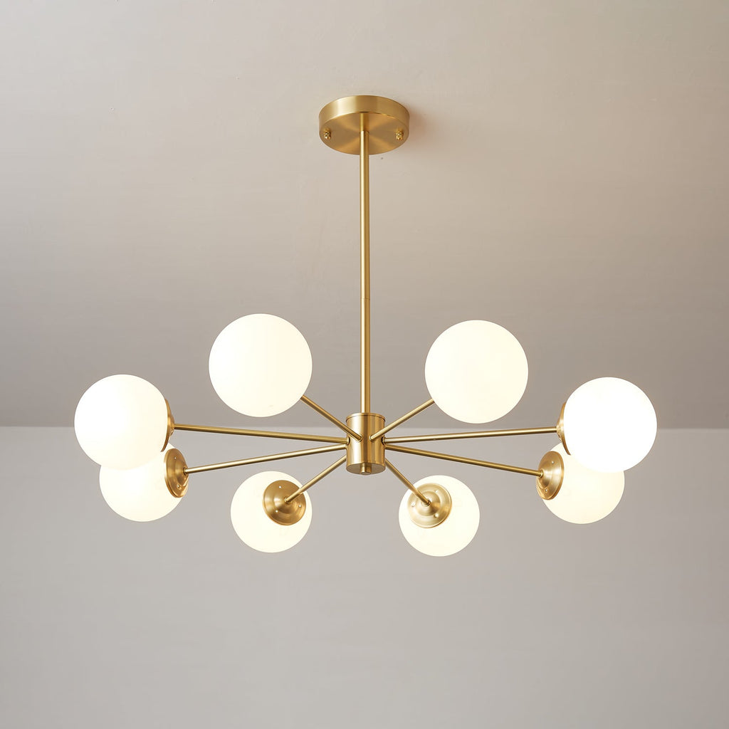 Clérachic chandelier with eight glowing orbs on thin brass arms in a balanced, symmetrical spread.