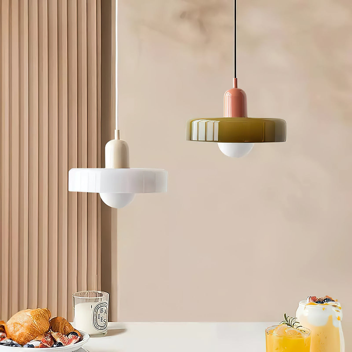 A white disc with a beige cap and an olive-green disc with a pink cap hang before warm ribbed panelling, a Clérachic pairing.