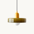 A glossy olive-green disc with a bright yellow cap and frosted globe on a plain white backdrop, from Clérachic.