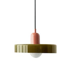A Clérachic olive-green disc pendant with a pink cap, black cord and frosted globe, shown on a plain white backdrop.