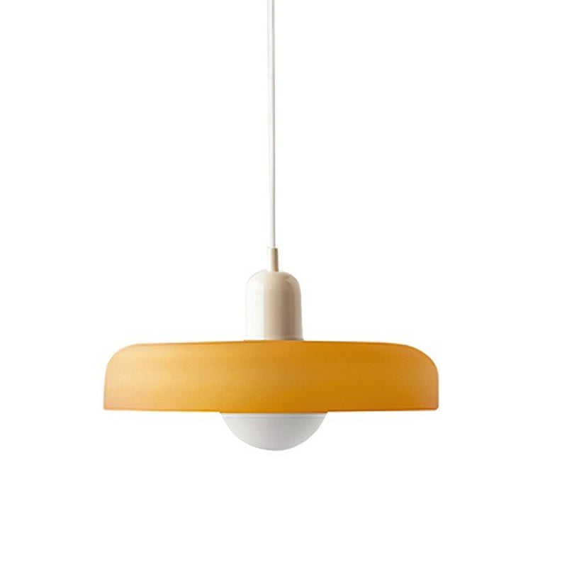 A frosted orange disc with a beige cap and a white cord, with a round white globe beneath, on a plain white backdrop, from Clérachic.
