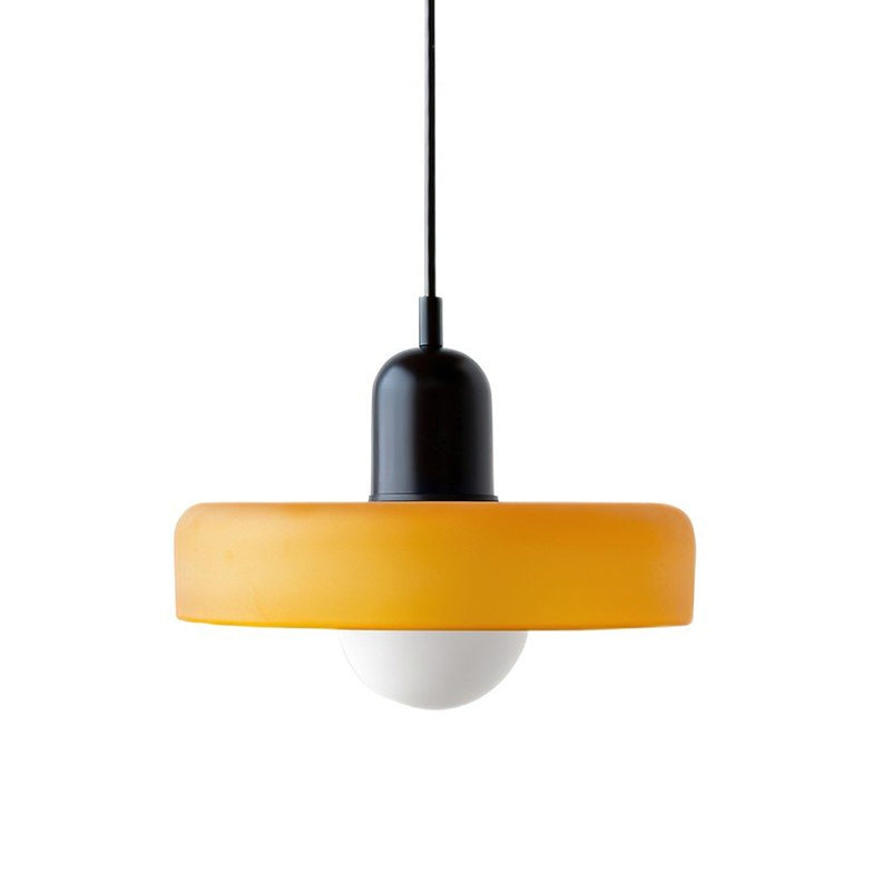 Matt orange disc pendant with a black cap and a black cord, a frosted globe hanging below, on white, from Clérachic.