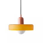 A soft orange disc with a pink cap and a black cord, a frosted globe below, on a plain white backdrop, from Clérachic.