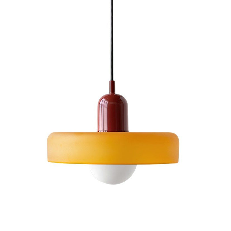 A Clérachic orange disc pendant with a deep red cap, black cord and frosted globe, shown on a white backdrop.
