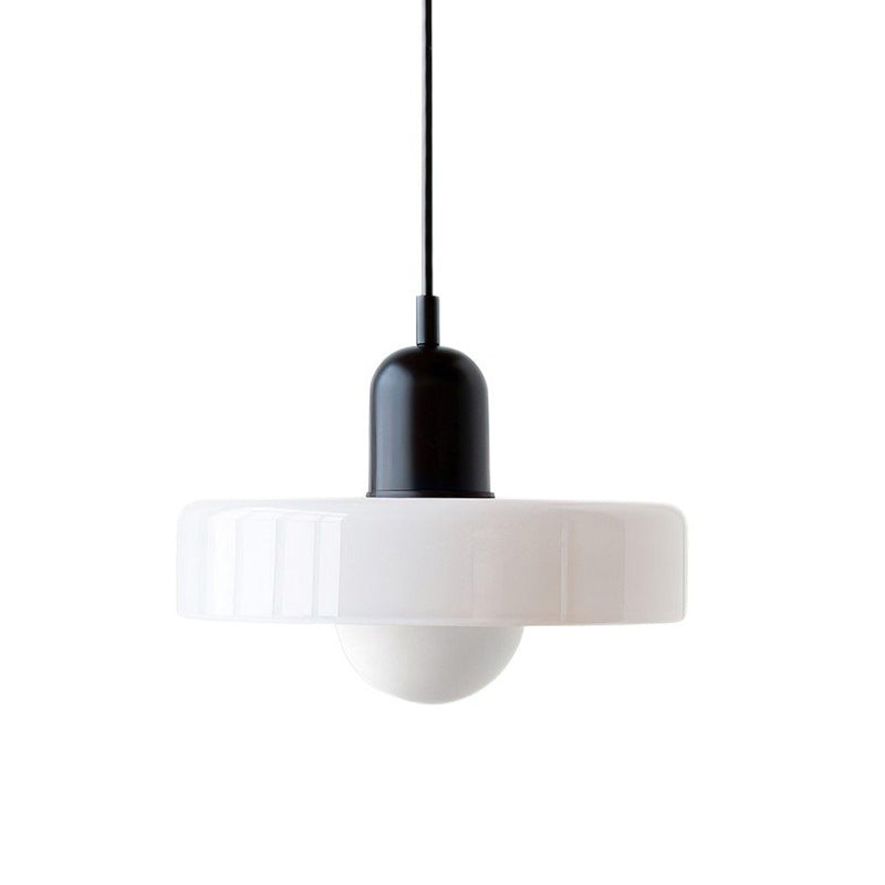 A white glossy disc with a black cap and black cord, a round frosted globe hanging below, on white, from Clérachic.
