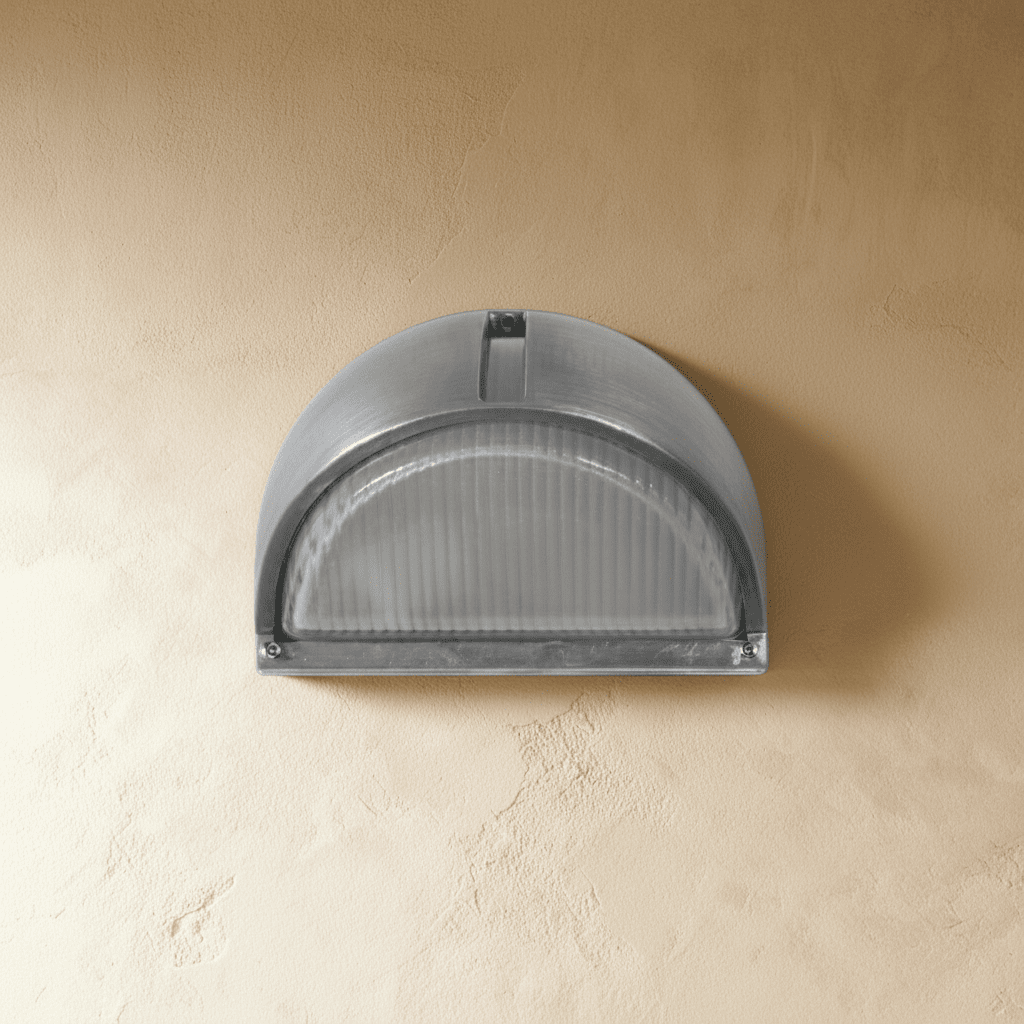 Clérachic half-dome aluminium outdoor wall lamp switched off, ribbed frosted glass under a brushed metal hood on a limewash wall.
