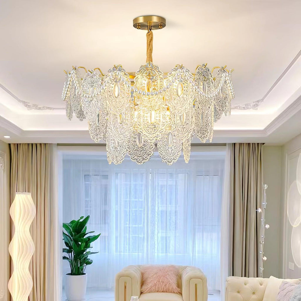 Clérachic glass chandelier lit in a living room with a moulded ceiling, a cream sofa and a tall white floor lamp.