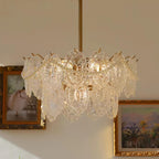 Clérachic chandelier with two rows of patterned glass panels and pearl swags, beside two framed paintings.