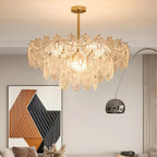 Clérachic glass chandelier in a living room with a geometric artwork and an arched chrome floor lamp.