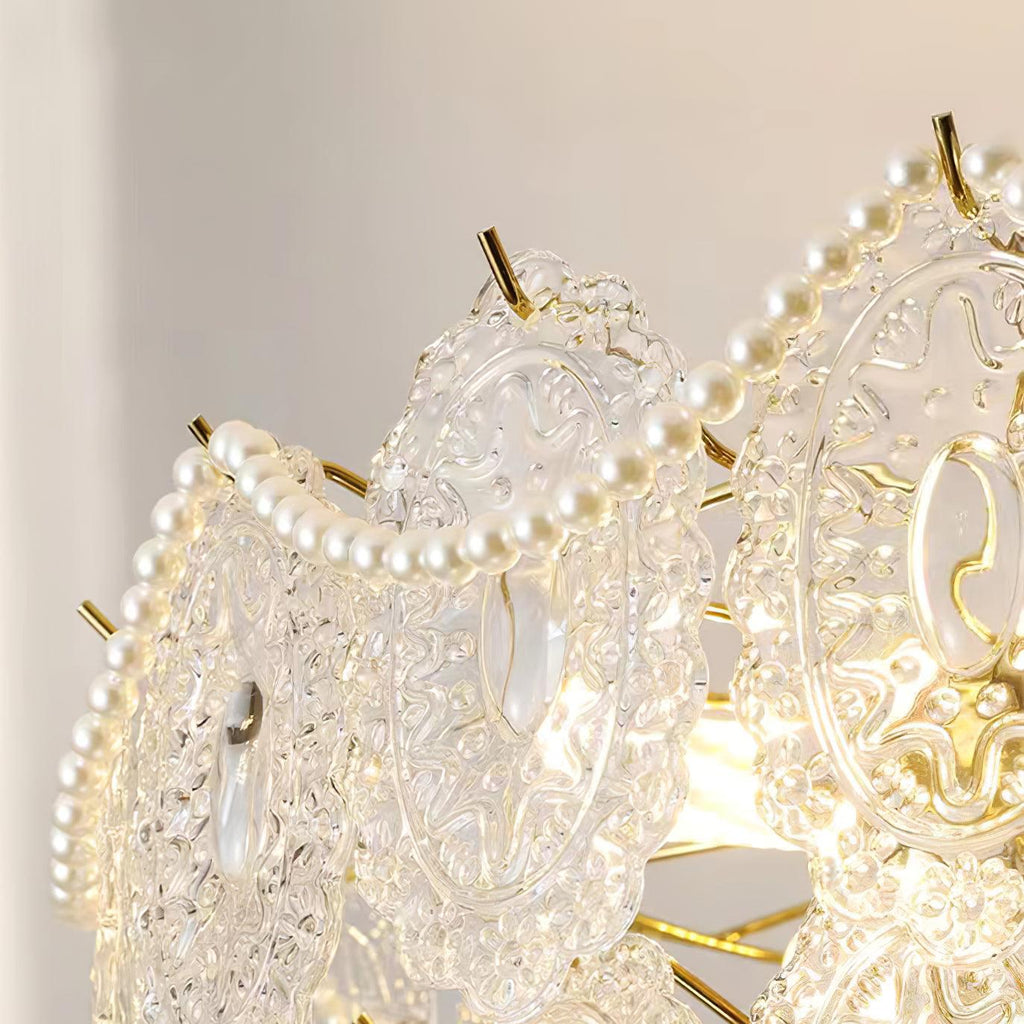 Close-up of one embossed glass panel and a strand of pearl beads on this Clérachic chandelier, with a gold prong.