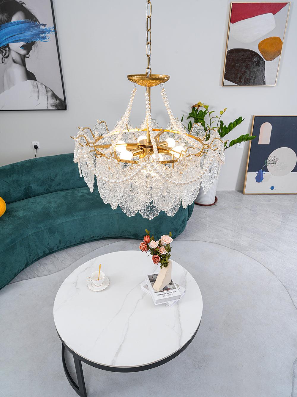 View from above of this Clérachic pendant light in a room with a curved green sofa, a white marble table and framed art on the walls.