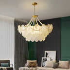 This Clérachic pendant light glows in a living room with a dark slatted wall, a green panelled corner, sheer curtains and a grey sofa.