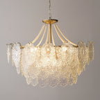 Clérachic pendant light with wide embossed glass panels and short pearl strands, lit against a plain grey wall on a gold-finish chain.