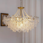 A Clérachic pendant with wide glass petals and pearl swags hanging beside a gilt-framed portrait and a pleated curtain.