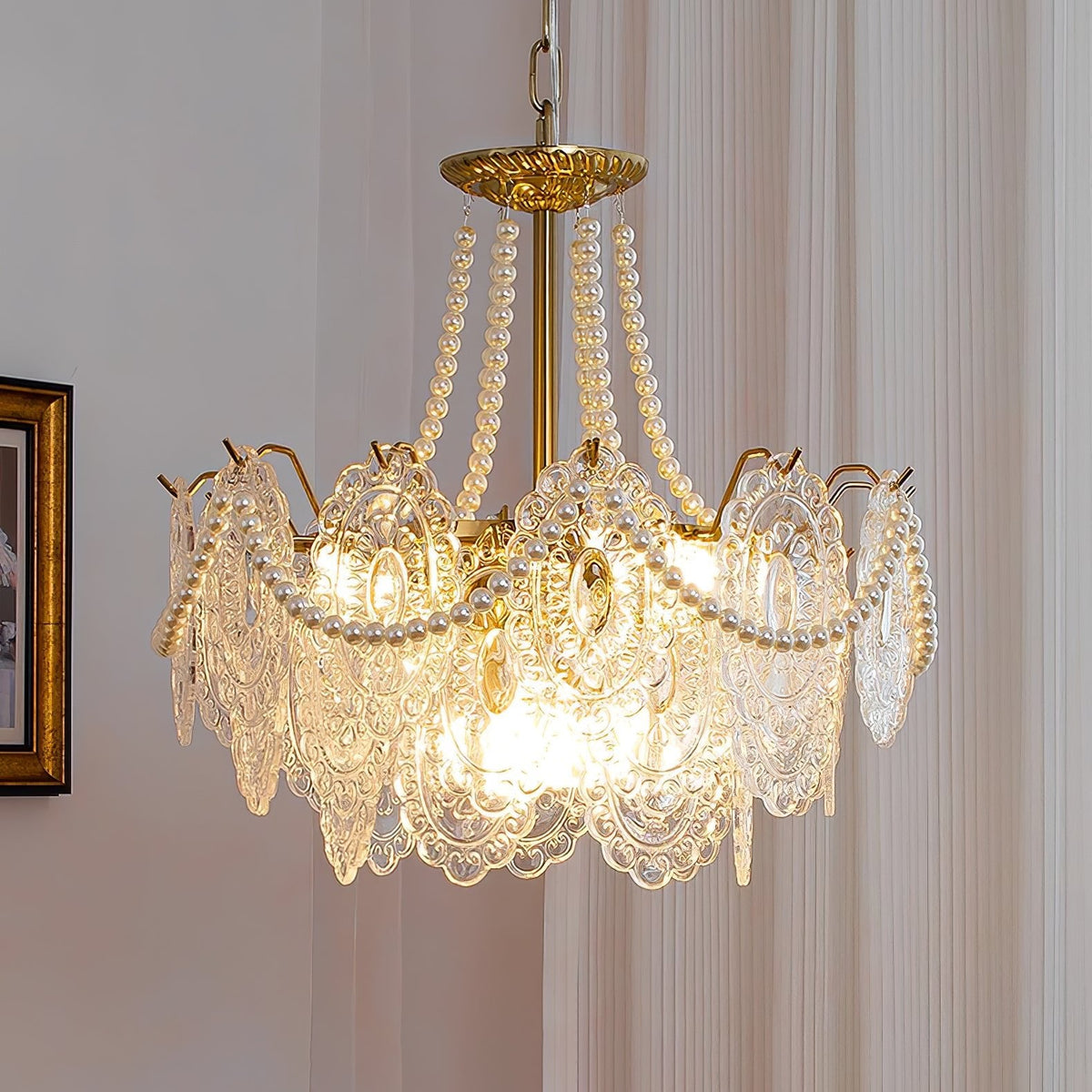 Close view of the glowing Clérachic pendant, with strands of pearls rising from the gold canopy to the rim of embossed glass panels.