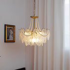Clérachic pendant lit beside a framed portrait and a floor-length curtain, with a gold canopy, pearl swags and embossed glass panels.