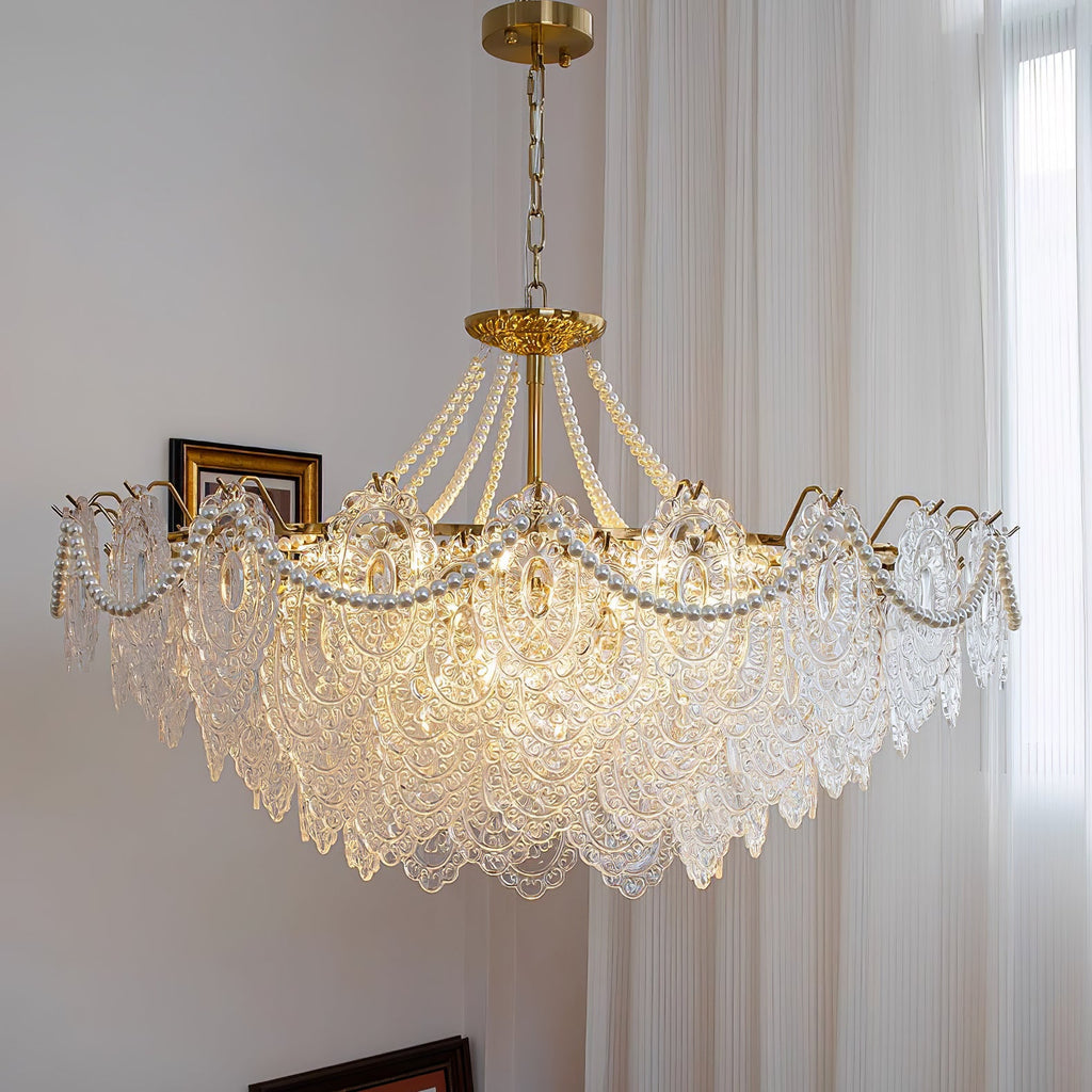 Wide Clérachic pendant with an even skirt of embossed glass and pearl swags, lit beside tall curtains and a framed picture.