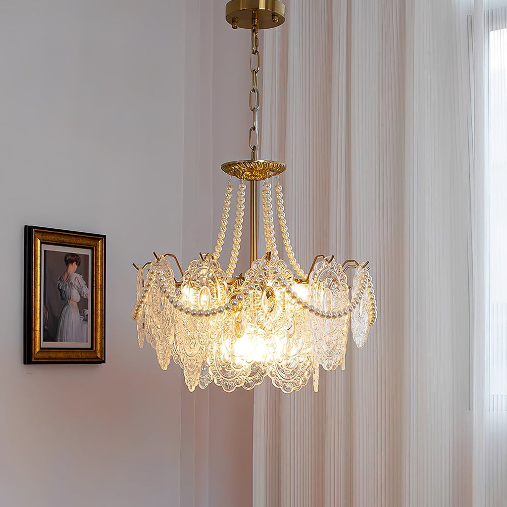 Lit Clérachic pendant with pearl swags and embossed clear glass panels, hanging on a chain beside a framed portrait and a curtain.