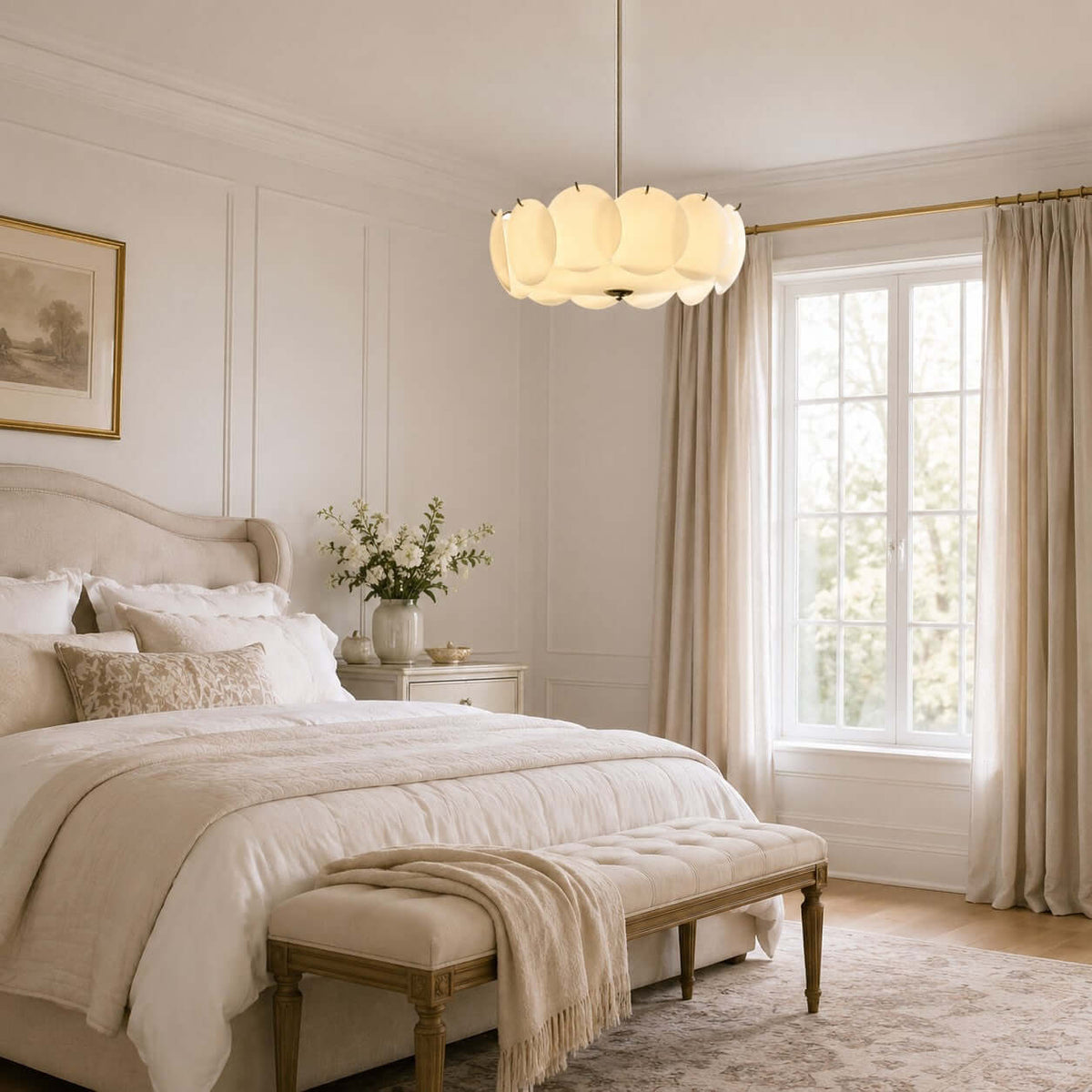 Clérachic glass-disc pendant hanging over a bedroom with a tufted bench and a cream bed, beside a window with linen curtains.