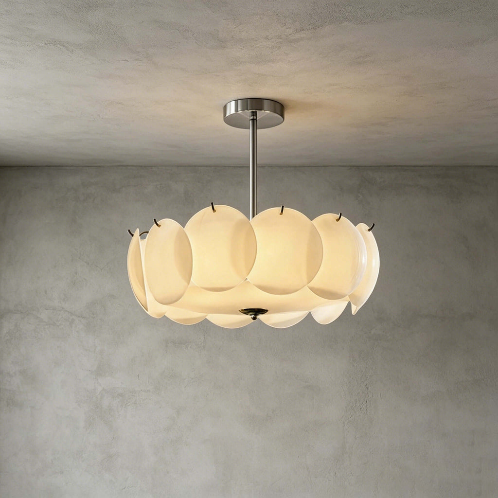 Chrome-finish Clérachic pendant of white glass discs against a grey plaster wall and ceiling, lit and viewed straight on.