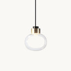 Clear glass pendant with a soft white inner glow and a gold-finish metal collar, shown on a plain white backdrop from Clérachic.