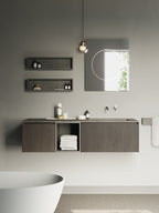 A Clérachic glass pendant hangs high above a bathroom vanity with a framed mirror, shelves and a freestanding white bath.
