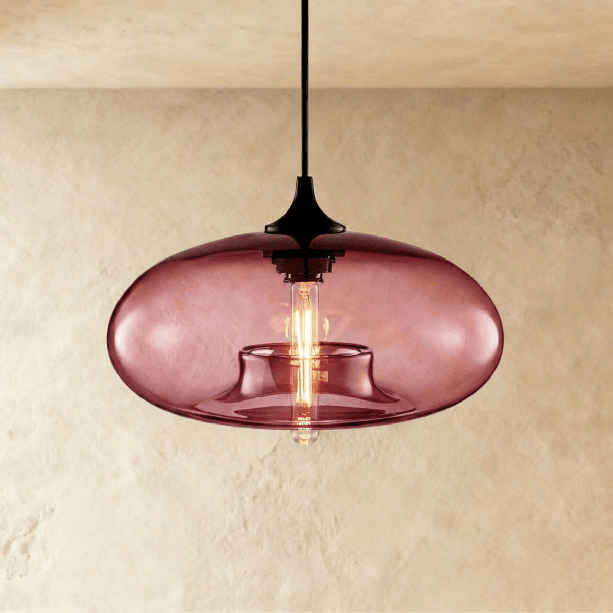 Clérachic pendant light with a dusky wine-red glass oval shade, black cord and cap, and a warm tube bulb glowing inside.