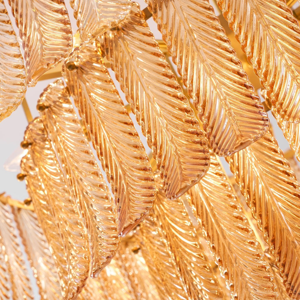 Close view of the veined amber glass leaves, overlapped and held on a brass frame, on this Clérachic pendant.