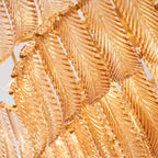 Close view of the veined amber glass leaves, overlapped and held on a brass frame, on this Clérachic pendant.