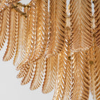 Close view from below of rows of ribbed amber glass leaves hanging in layers on this Clérachic pendant.