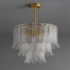 A Clérachic round pendant of clear ribbed glass leaves in three tiers, hung from a brass rod and canopy on dark grey.