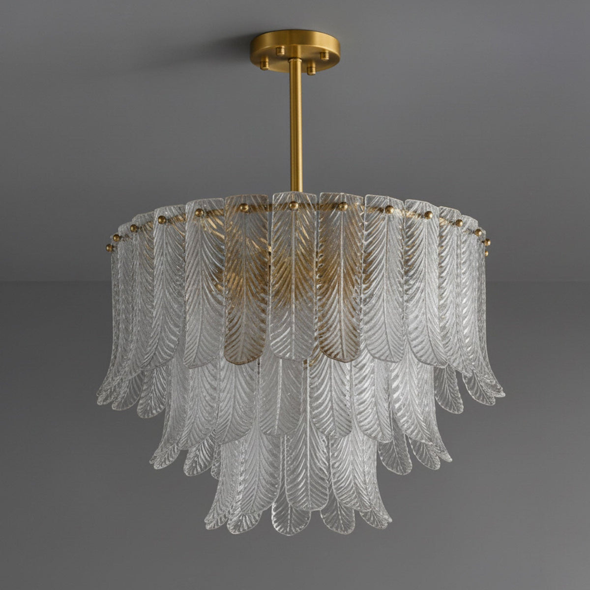 A Clérachic round pendant of clear ribbed glass leaves in three tiers, hung from a brass rod and canopy on dark grey.