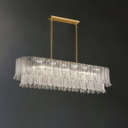 Clear glass leaves on a long oval frame make up this Clérachic linear pendant, hung from a brass bar on a dark grey wall.