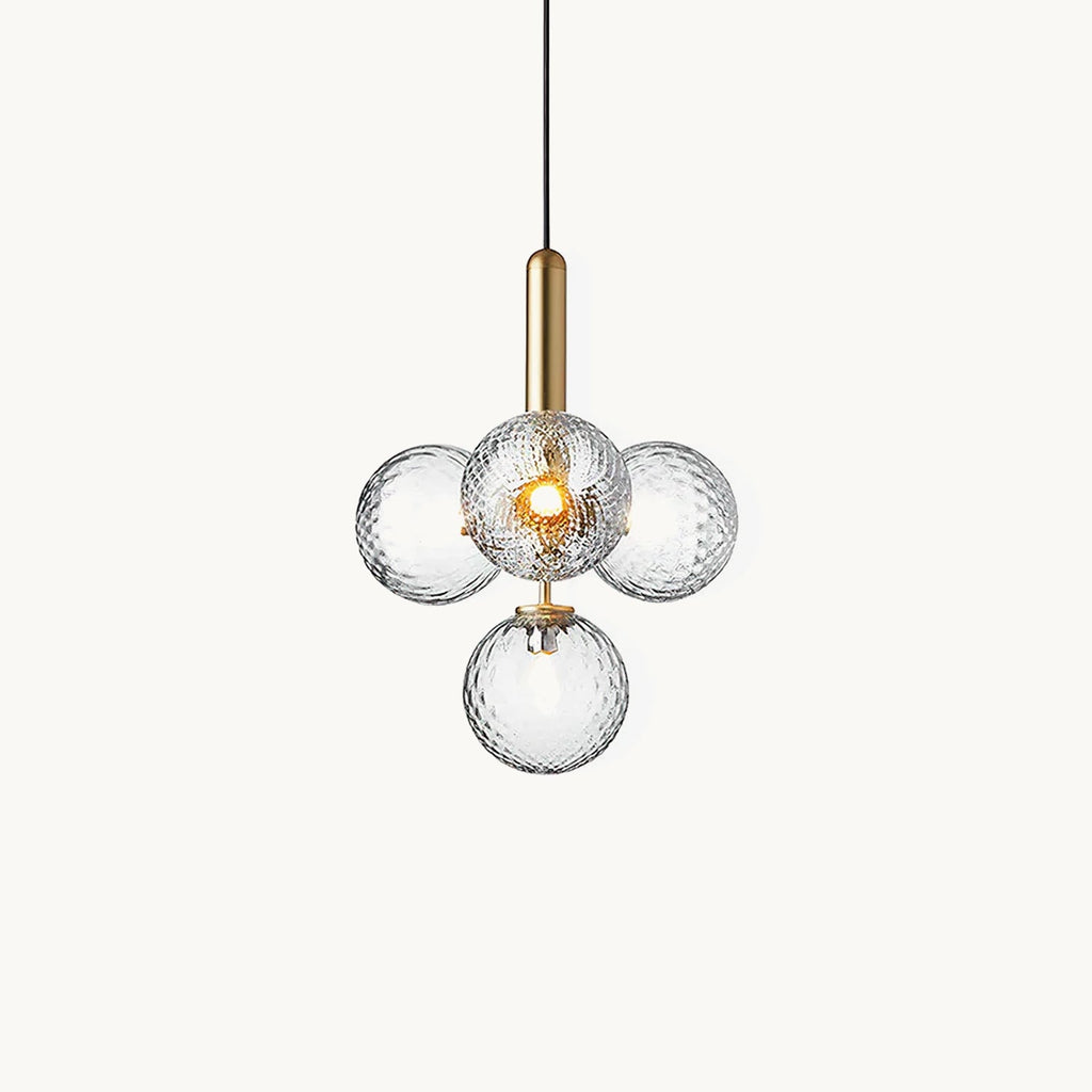 Clérachic pendant with four clear textured glass globes on a brass rod, shown lit against a plain white backdrop.
