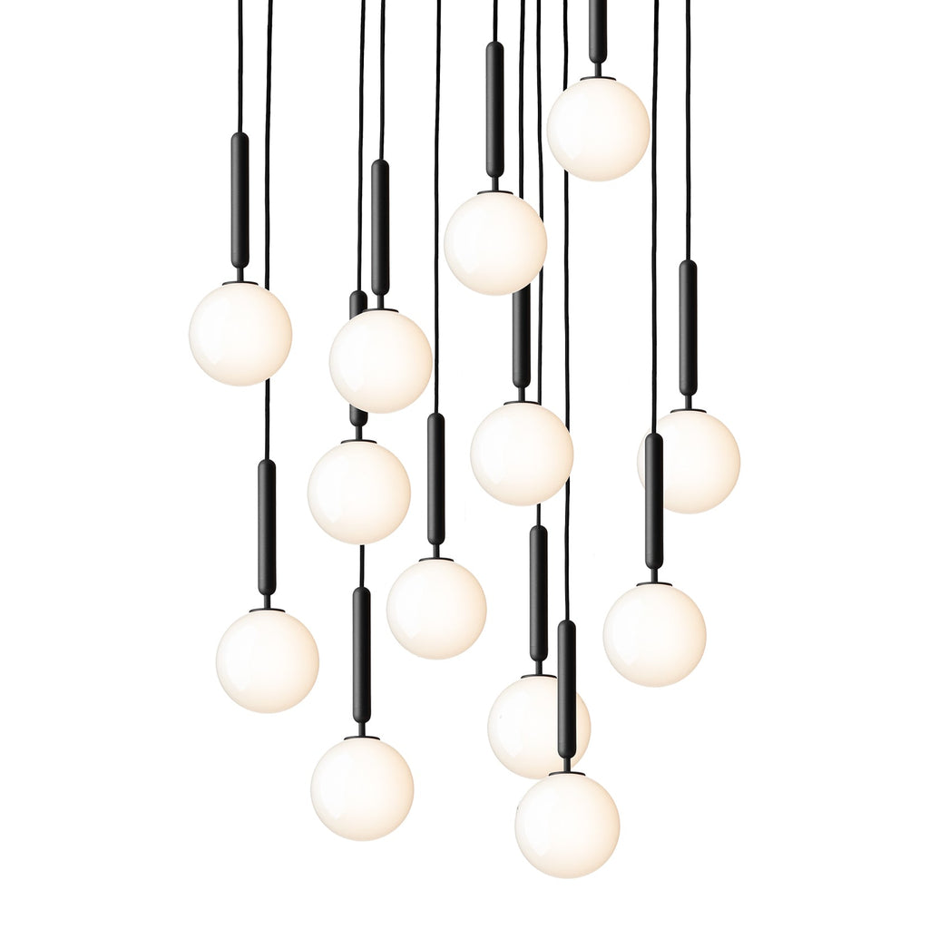 A tall cascade of Clérachic pendants with white opal globes on black rods, glowing warm on a white background.