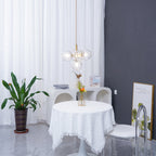 Small gold-rod Clérachic cluster pendant seen from a distance in a bright room with white curtains and a round table.