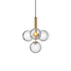 Clérachic four-globe pendant in clear textured glass with a brass rod, cut out on a white background.