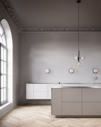 Clérachic glass cluster pendant hanging in a tall room with arched windows, a white kitchen island and wall lights.