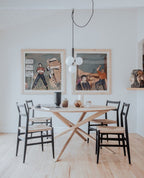 Clérachic cluster pendant with white globes hangs on a long cord above a light oak table and wishbone chairs.