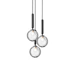 Three Clérachic pendants with clear textured globes on black rods, shown at different heights on white.