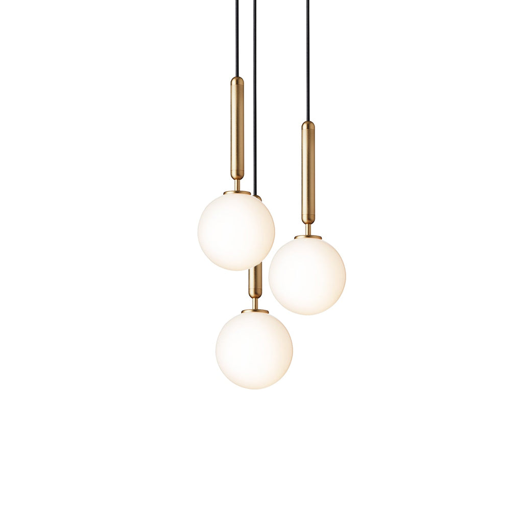 Three white opal globes on brass rods, a Clérachic pendant trio lit warm on a plain white backdrop.