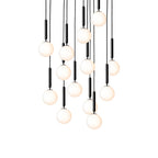 Clérachic pendants with white opal globes on black rods hang in a long cascade, lit warm on a white background.