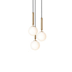 Clérachic pendant trio with white opal globes on brass rods, lit warm and hung close on a white background.