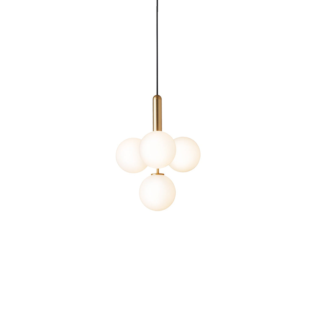 Clérachic four-globe cluster pendant with white opal globes on a brass rod, lit warm on white.